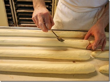 le boulanger pratique des incisions sur le sommet avec une lame très coupante, créant ainsi des "grignes". Cette coupe crée des faiblesses dans la croûte du pain qui lui permettront de bien gonfler pendant la cuisson. 